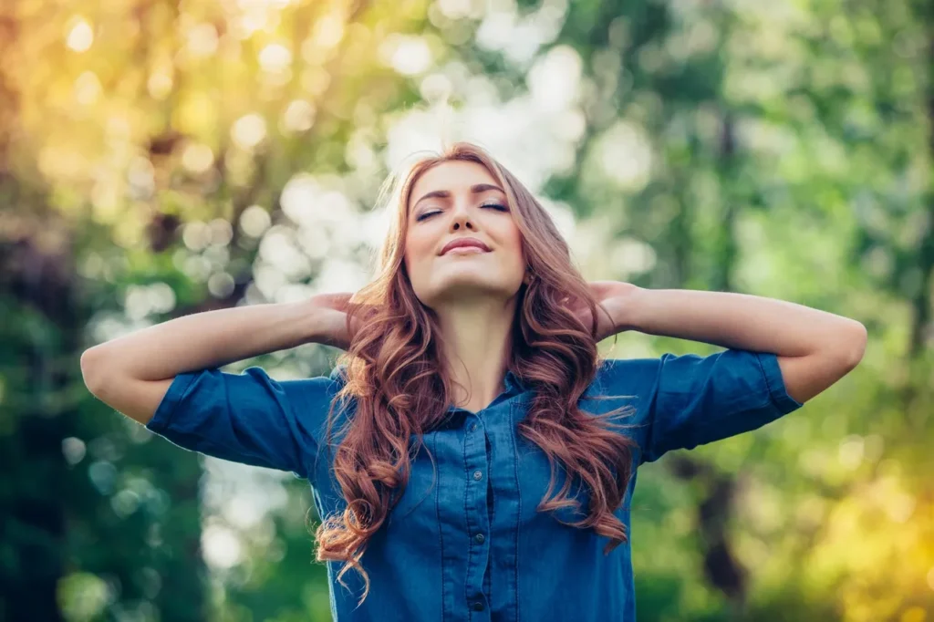 A woman with her hands behind her head.