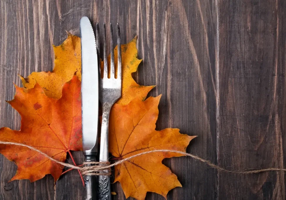 A fork and knife sitting on top of some leaves.