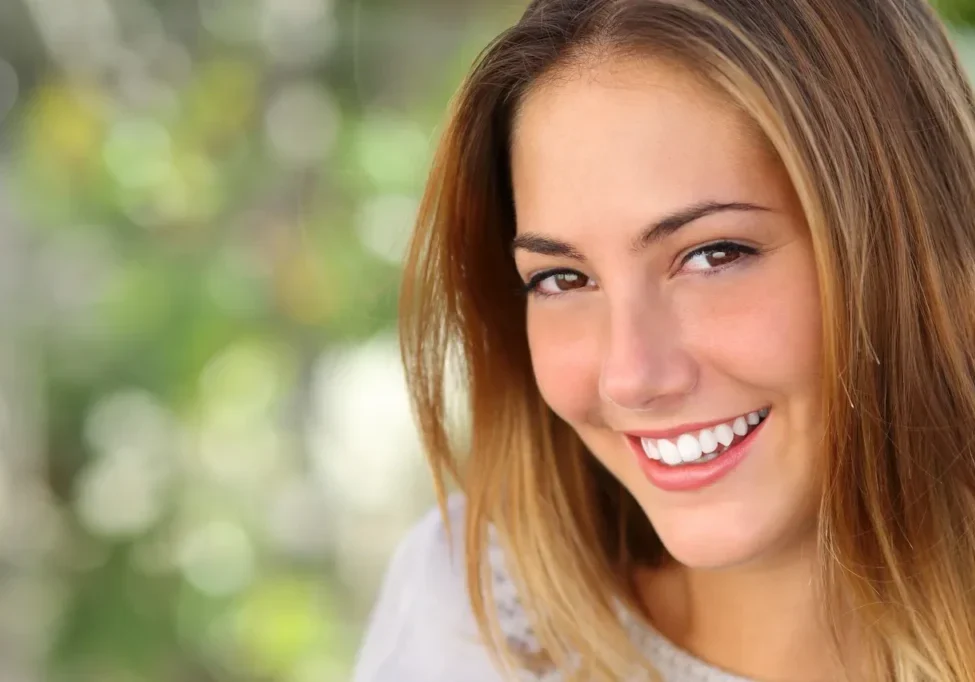 A woman with white teeth smiling for the camera.