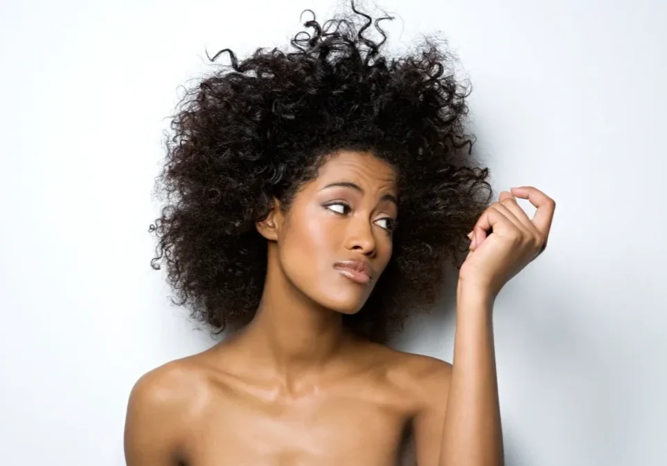 A woman with very long hair is posing for the camera.