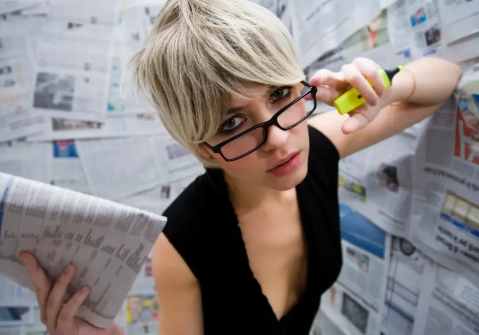 A woman with glasses is holding a phone